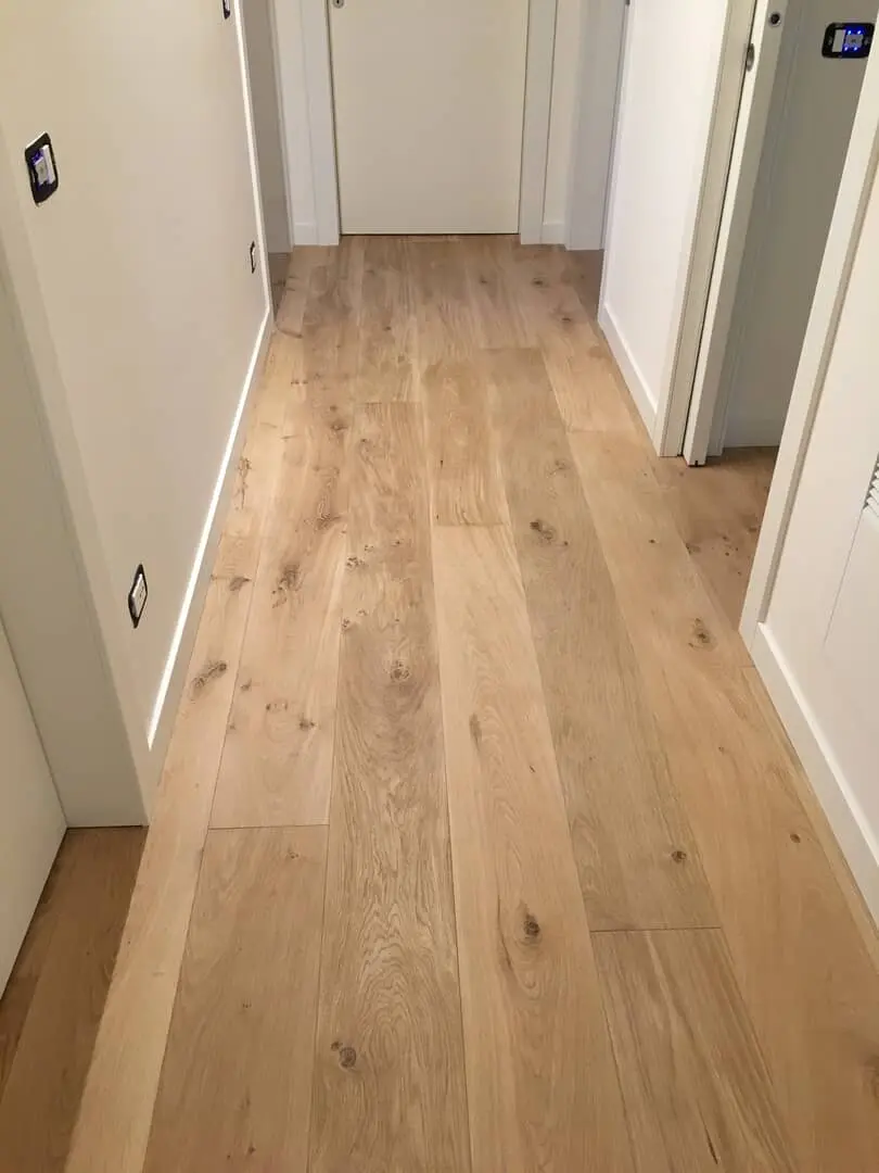 Corridoio luminoso con pavimento in legno.