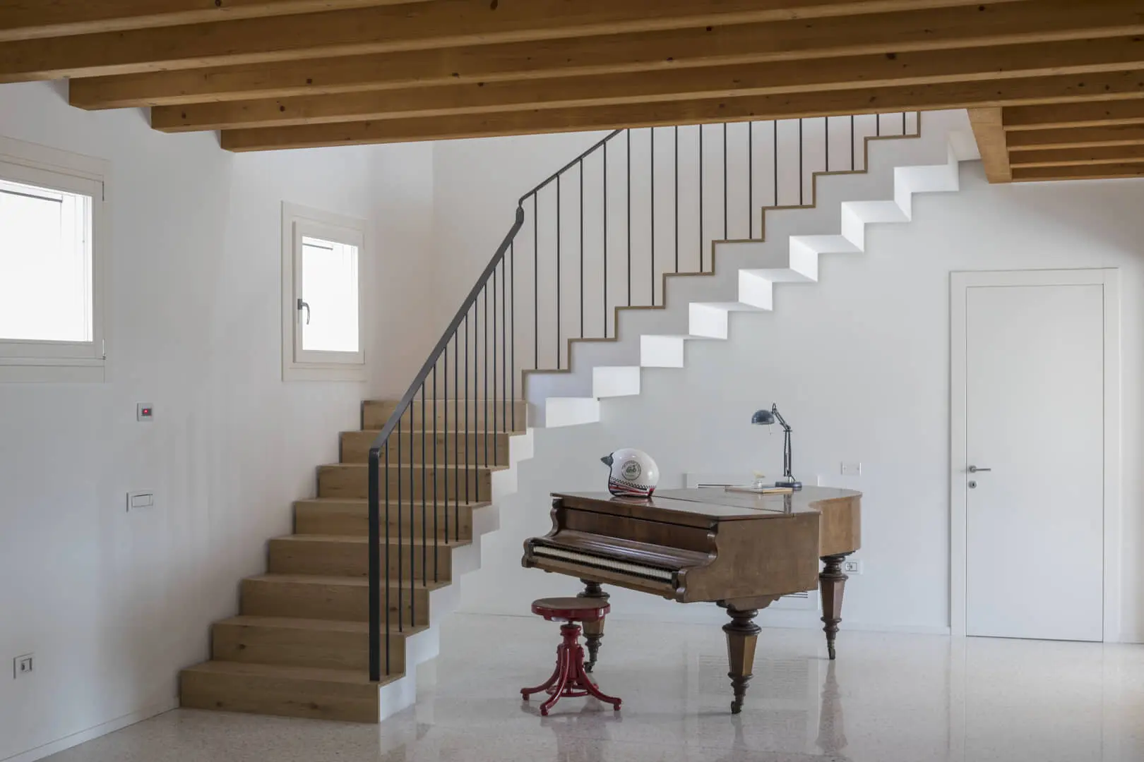 Scala moderna in legno e acciaio con pianoforte.